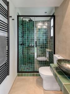 a bathroom with a shower and a toilet and a sink at Muse Urban Suites in Athens