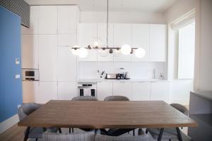 una cucina con tavolo da pranzo e sedie in legno di FLH Augusta's Arch Design Apartment a Lisbona