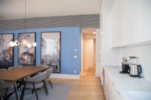 eine Küche und ein Esszimmer mit einem Tisch und Stühlen in der Unterkunft FLH Augusta's Arch Design Apartment in Lissabon