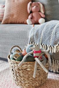 a basket filled with stuffed animals on a couch at Stay KooooK Bern Wankdorf - Online Check In in Bern