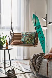 um baloiço de varanda numa sala de estar com um sofá em Stay KooooK Bern Wankdorf - Online Check In em Berna