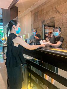 a woman is standing at a counter in a restaurant at The B Hotel Alabang in Manila