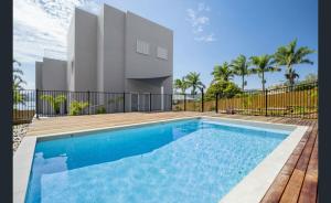 a swimming pool in front of a house at Splendeur Sur La Mer - One Bedroom in Airlie Beach