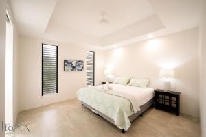 a white bedroom with a bed and a window at Splendeur Sur La Mer - Two Bedroom in Cannonvale +6 photos