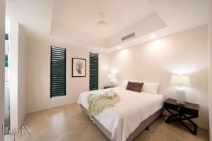 Un dormitorio blanco con una cama grande y una mesa. en Splendeur Sur La Mer - Three Bedroom, en Airlie Beach 8 fotos más