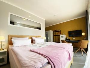 a bedroom with a large bed with a pink blanket on it at Burghof Kyffhäuser in Bad Frankenhausen