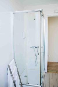 a glass shower door in a room with chairs at Casa João Chagas Guesthouse, Constância in Constância