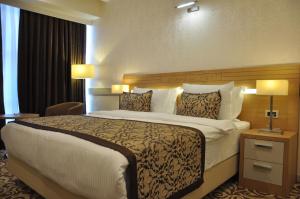 デニズリにあるGrand İtimat Hotelのホテルルーム内のベッドルーム1室(大型ベッド1台付)