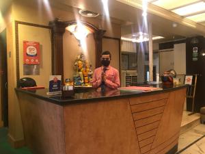 a man wearing a mask standing at a bar at Hotel Shivkrupa in Pune