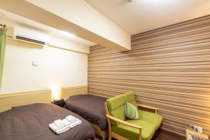 宜野灣的住宿－露台度假8號公寓式酒店，一间卧室配有一张床和一把绿色椅子