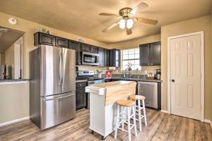 a kitchen with a stainless steel refrigerator and wooden floors at Surfside Retreat Steps to Beach and Local Eats! in Surfside Beach