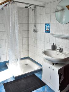 a bathroom with a sink and a shower and a tub at Ferienwohnung Zum Steinberg in Bredstedt +19 photos