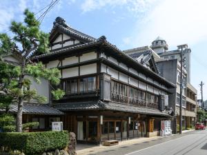 ein asiatisches Gebäude mit einem Turm auf einer Straße in der Unterkunft Tabist Asanokan Annex Iroha Ise in Ise