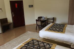 a hotel room with two beds and a table with a table at Al Diyar Hotel in Nizwa