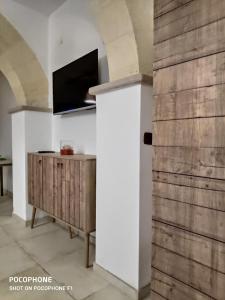 a living room with a tv and a wooden wall at Appartamento Suite Santa Teresa in Taranto