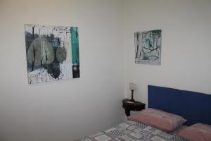 ナポリにあるB&B Villa in Rivieraのベッドルーム1室(ベッド1台付)が備わります。壁に2枚の写真が飾られています。