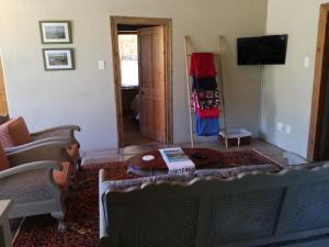 a living room with a couch and a table at The Apple Blossom Cottage in Villiersdorp