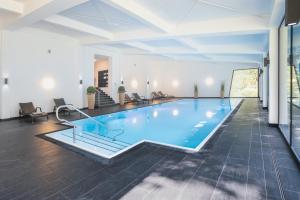 a large swimming pool in a large room at Waldhotel Berghof in Luisenthal