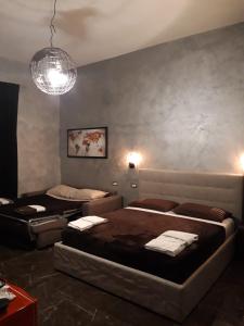 una camera con due letti e un lampadario a braccio di B&B Roma Royal Residence a Roma