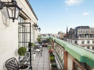 a balcony with chairs and a view of a city at The Langham London in London