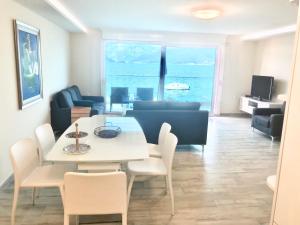 Lux Apartments Krasici في كراشيسي: غرفة معيشة مع طاولة وكراسي والمحيط