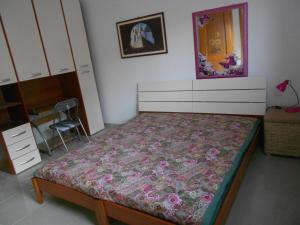 a bedroom with a bed with a dresser and a mirror at Casa Batti in Oristano