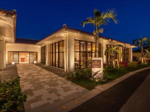 ein Haus mit einer Palme davor in der Unterkunft FUSAKI BEACH RESORT HOTEL & VILLAS in Ishigaki-jima
