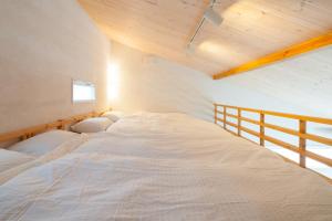 葉山町にある南葉山 - Seaside Cabin in Minami-hayamaの木製天井の客室で、白い大型ベッド1台が備わります。