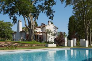 uma casa com piscina em frente a uma casa em Grandono Agriturismo in Maremma em Scansano