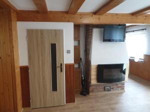a door in a room with a fireplace and a tv at Chata Seeberg in Poustka