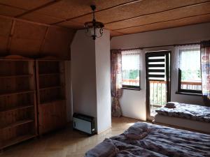 a bedroom with a bed and two windows in it at Chata Seeberg in Poustka