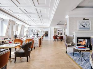 a living room with chairs and a fireplace at The Langham London in London