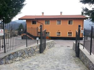 dom z płotem przed nim w obiekcie La Locanda di San Biagio w mieście Bolzaneto