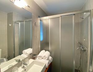 La salle de bains est pourvue d'un lavabo et d'une douche. dans l'établissement Panorama Boutique Hotel, à Fira