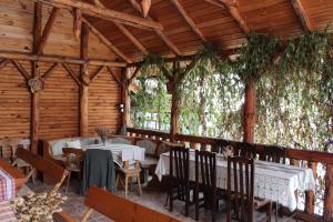 a restaurant with tables and chairs in a room with trees at Pensiunea Iulia in Bran
