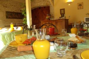 a table with a jug of orange juice on it at Le Clos des Palmiers in Saint-ouen-dʼAunis