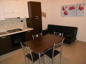 a kitchen and dining room with a table and a couch at Casa Batti in Oristano