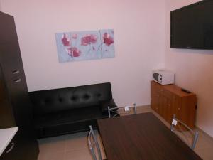 a living room with a black couch and a table at Casa Batti in Oristano