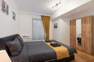 ein Schlafzimmer mit einem Bett, einem Sofa und einem Fenster in der Unterkunft Varna Smart Home Apartments in Warna