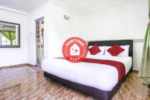 a bedroom with a bed with a sign on it at D' Anjung Inn in Tangkak
