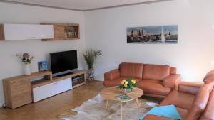 ein Wohnzimmer mit einem Sofa und einem TV in der Unterkunft Summerset Ferienwohnung in Rosengarten