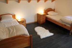 een slaapkamer met 2 bedden en 2 nachtkastjes met lampen bij Chalet de la Rigue in La Bresse