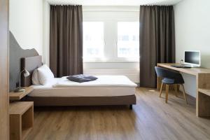 Voodi või voodid majutusasutuse Tailormade Hotel STANS SÜD toas