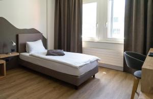 Voodi või voodid majutusasutuse Tailormade Hotel STANS SÜD toas