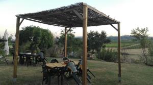 un pabellón de madera con mesas y sillas en un patio en Agriturismo La Chiesina, en Abbadia di Montepulciano