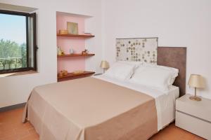 um quarto com uma cama grande e uma janela em Grandono Agriturismo in Maremma em Scansano