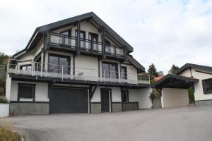 een groot wit huis met een balkon bij Chalet de la Rigue in La Bresse