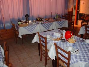 una sala da pranzo con tavoli e sedie con cibo sopra di Agriturismo Mulinu Betzu a San Vero Milis