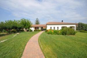 a house with a grassy yard with a pathway at Agriturismo Mulinu Betzu in San Vero Milis