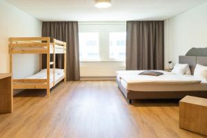 Voodi või voodid majutusasutuse Tailormade Hotel STANS SÜD toas